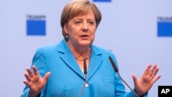 German chancellor Angela Merkel gestures during a discussion with TRUMPF employees in Neukirch, eastern Germany, Aug. 16, 2018.