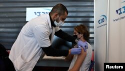 Arhiva - Tinejdžer prima vakcinu protiv Kovida 19, u Telavivu, Izrael, 24. januara 2021. (Rojters)