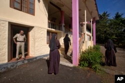 A policeman stands guard as nuns who have supported the accusation of rape against Bishop Franco Mulakkal return from the chapel in St. Francis Mission Home in Kuravilangad in the southern Indian state of Kerala, Nov. 4, 2018.