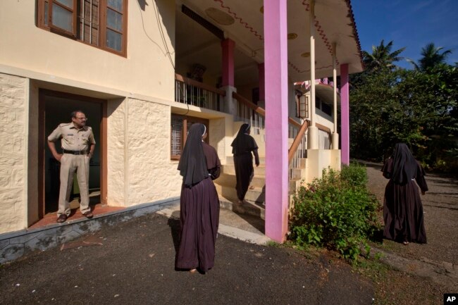 A policeman stands guard as nuns who have supported the accusation of rape against Bishop Franco Mulakkal return from the chapel in St. Francis Mission Home in Kuravilangad in the southern Indian state of Kerala, Nov. 4, 2018.