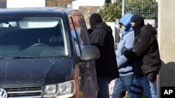 A detained man is escorted by police after a raid in the town of Michalovce, eastern Slovakia, March, 1. 2018. Police were conducting raids in eastern Slovakia on Thursday in houses linked to members of the Italian Mafia, about whom an investigative journalist was writing before he was shot dead last week.