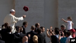 A worshipper tosses a hat into the air as Pope Francis arrives for his weekly general audience in St. Peter's Square, at the Vatican, in Rome, June 10, 2015.