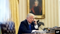 FILE - President Donald Trump speaks on the phone in the Oval Office of the White House in Washington, Jan. 28, 2017. Desperate for a legislative victory, Trump is upping the pressure on lawmakers to act on several initiatives.