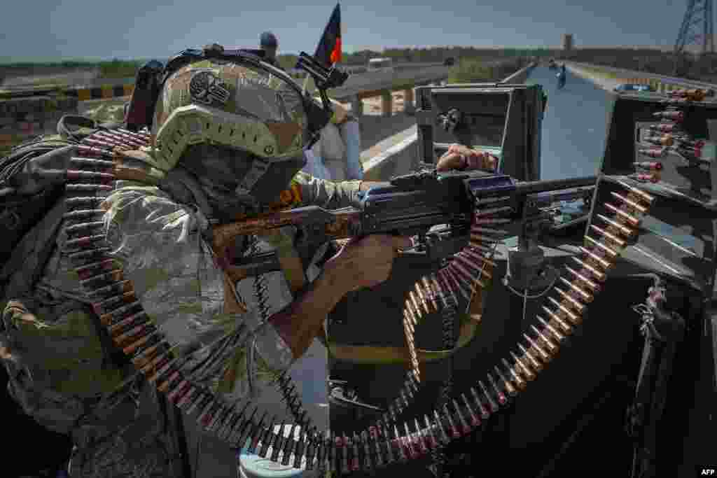 A security personnel stands guard on top of a vehicle outside United Nations Assistance Mission in Afghanistan (UNAMA) office compound in Guzara district of Herat province, July 31, 2021.