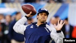 Seattle Seahawks quarterback Russell Wilson warms up before his team plays the Denver Broncos in the NFL Super Bowl XLVIII football game in East Rutherford, New Jersey, Feb. 2, 2014.
