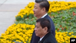Philippine President Rodrigo Duterte, front, walks with Chinese President Xi Jinping during a welcome ceremony outside the Great Hall of the People in Beijing, China, Oct. 20, 2016.