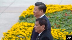 Presiden Filipina Rodrigo Duterte (depan) berjalan bersama Presiden China menuju Balai Rakyat China di Beijing, untuk mengikuti upacara penyambutan kenegaraan terkait kunjungannya di negara itu, 20Oktober 2016 (AP Photo/Ng Han Guan).