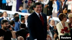 Turkey's Foreign Minister Ahmet Davutoglu greets supporters during a meeting of the ruling AK Party (AKP), in Ankara, August 27, 2014. 