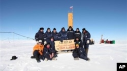 Russian researchers at the Vostok station in Antarctica after reaching subglacial Lake Vostok. Scientists hold a sign reading "05.02.12, Vostok station, boreshaft 5gr, lake at depth 3769.3 metres."