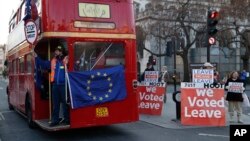 Demonstran Anti-Brexit menyewa sebuah bus kota London melewati para demonstran pendukung Brexit di depan gedung parlemen Inggris di London, Senin (28/1). 