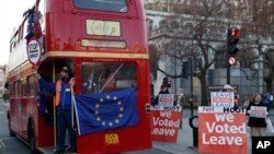 Anti-Brexit protesters on board a hired red London bus demonstrate as they drive past the Houses of Parliament in London, Jan. 28, 2019. 
