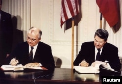 FILE - U.S. President Ronald Reagan and Soviet President Mikhail Gorbachev sign the Intermediate-range Nuclear Forces Treaty at the White House, Dec. 8 1987.