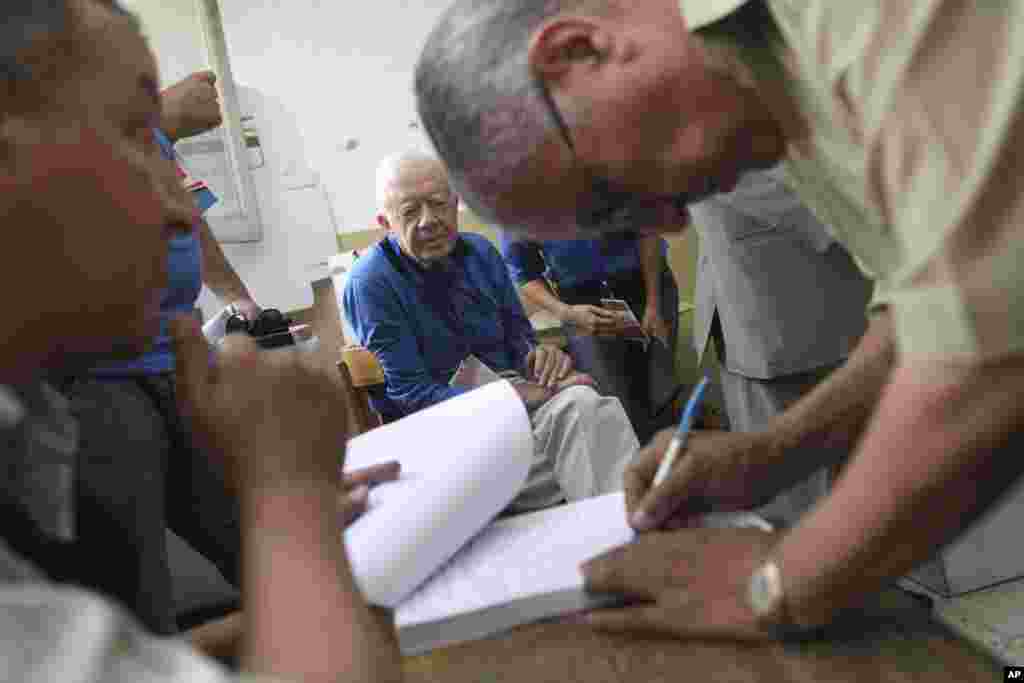 Former U.S. President Jimmy Carter, center, observes the election process inside a polling station in the Sayeda Aisha neighborhood of Cairo, Egypt, Wednesday, May 23, 2012. The Carter Center is in Egypt to monitor the presidential elections. 