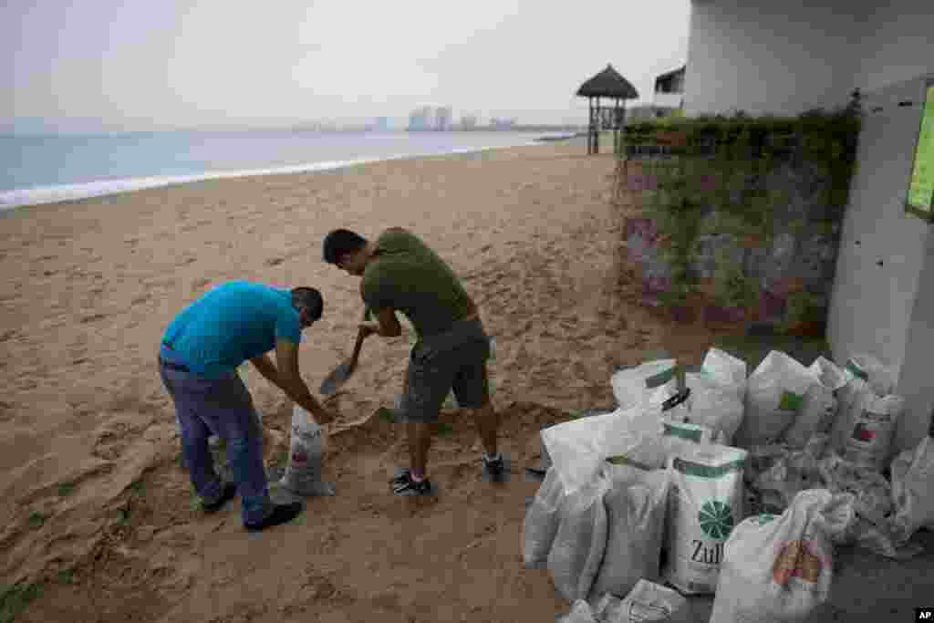 Men fill small bags with sand from the beach as they prepare for the arrival of Hurricane Patricia in Puerto Vallarta, Mexico.