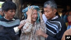 Villagers try to comfort a weeping woman, a relative of Khin Win, who was fatally shot Tuesday during a confrontation with a police and mine security guards at Letpadaung copper mine.