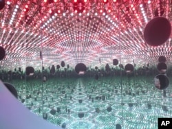 Colored lights appear in the Infinity Mirror Room created by Japanese artist Yayoi Kusama, part of the exhibit, "Yayoi Kusama: Festival of Life," on display at the David Zwirner gallery in the Chelsea section of New York, Nov. 21, 2017.