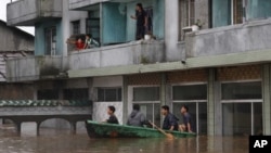 30일 평안남도 안주시에서 홍수로 차오른 물을 피해, 지붕과 발코니로 올라간 주민들.