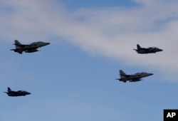 Newly-acquired FA-50PH fighter jets, top left and bottom right, escorted by Philippine Air Force S-211 jets, fly upon arrival in Philippine air space from South Korea, Nov. 28, 2015.