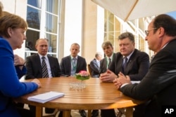 FILE - In a revived European push to bring peace to eastern Ukraine, (from left to right), German Chancellor Angela Merkel, Russian President Vladimir Putin, Ukrainian President Petro Poroshenko and French President Francois Hollande meet.