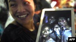 A happy family member shows a picture of the missing boys. (AFP PHOTO)