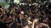 Migrants who were found at sea on a boat sit near Kanyin Chaung jetty after landing outside Maungdaw township, northern Rakhine state, Myanma,r June 3, 2015. 