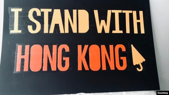 参与反警暴游行的中国留学生小黄制作的“我和香港站在一起”的牌子。（照片由当事人提供）
