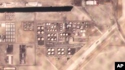 Dalam foto satelit ini tampak asap membubung dari depot minyak milik Abu Dhabi National Oil Co. setelah serangan udara yang diklaim oleh pemberontak Houthi terjadi di area tersebut pada 17 Januari 2022. (Foto: Planet Labs PBC via AP)