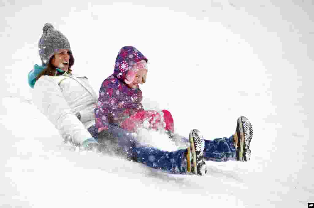 Mary Kay và con gái Lucy, 4 tuổi, trượt tuyết xuống một ngọn đồi ở Alexandria, bang Virginia, ngày 3/3/2014.