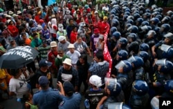 Protesters are blocked by riot police as they march to the U.S. Embassy to denounce the U.S. military's role to quell the two-month-long siege of Marawi city in southern Philippine by Muslim militants Saturday, July 22, 2017 in Manila, Philippines.