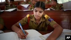 In this Friday Aug. 8, 2014 photo, a student writes notes inside a classroom at a Sainik School in the northeastern Indian state of Assam. 