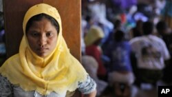 A Rohingya woman stands at a temporary shelter in Bayeun, Aceh Province, Indonesia, Monday, June 1, 2015. Since early May, thousands of boat people from Myanmar and Bangladesh have been brought ashore from Southeast Asian waters. 