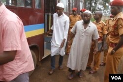 Suspects in the murder of Police Spokesperson Andrew Felix Kaweesi get out of the prison bus at the Nakawa Chief Magistrates Court in Kampala, Uganda, May 18, 2017. (H. Athumani/VOA)