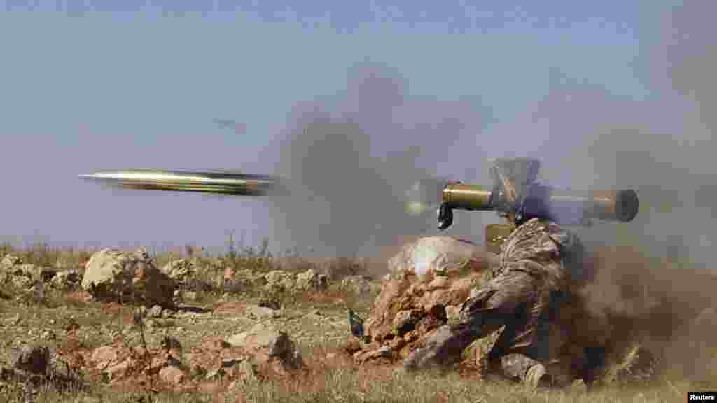 A Free Syrian Army fighter fires an anti-tank missile towards forces loyal to Syria's President Bashar al-Assad in the eastern Hama countryside. 
