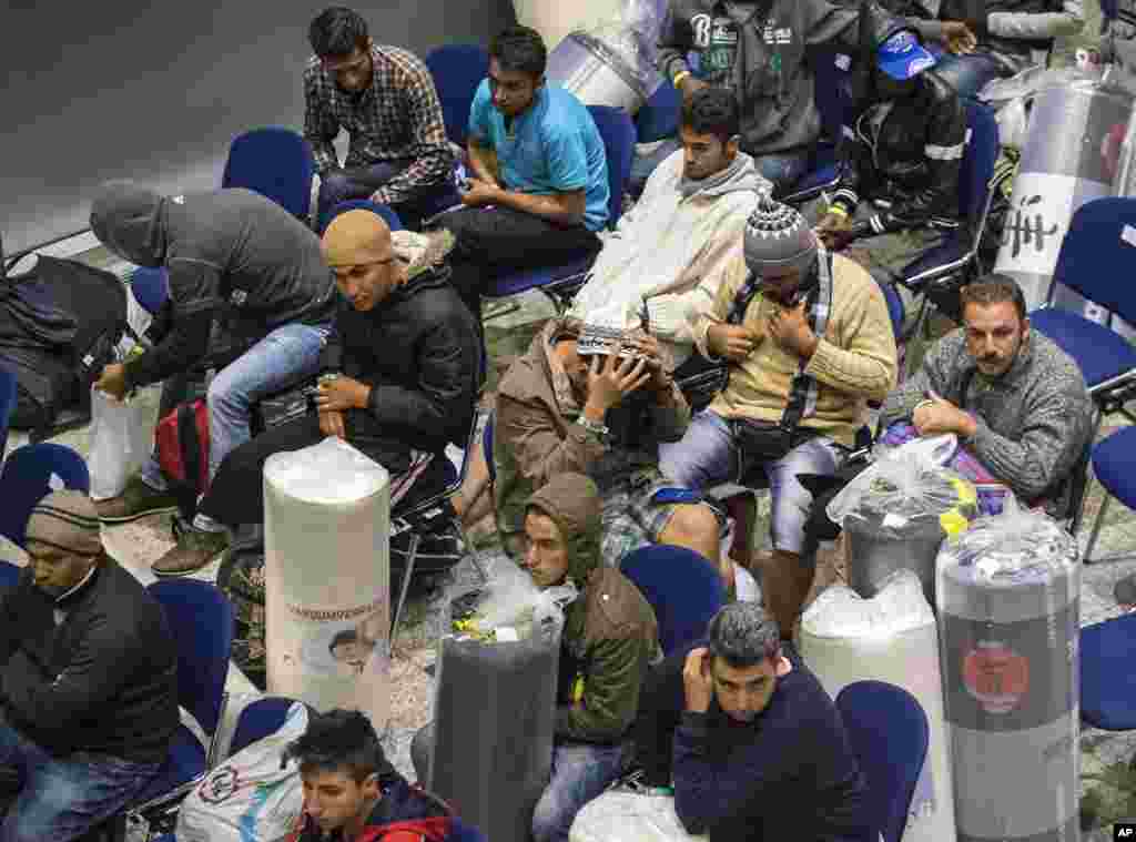 Refugees transported by busses from Munich wait after their arrival in one of the exhibition halls of the Trade Fair Messe Erfurt, in Erfurt, central Germany. Germany said it was willing to accept 800,000 migrants.