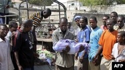 Сомалієць несе тіло дитини, вбитої під час мінометної атаки