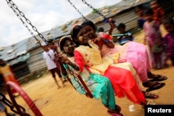 Rohingya refugee children ride on a swing ride on the day of Eid al-Adha in the Kutupalong refugee camp in Cox’s Bazar, Bangladesh, Aug. 22, 2018.