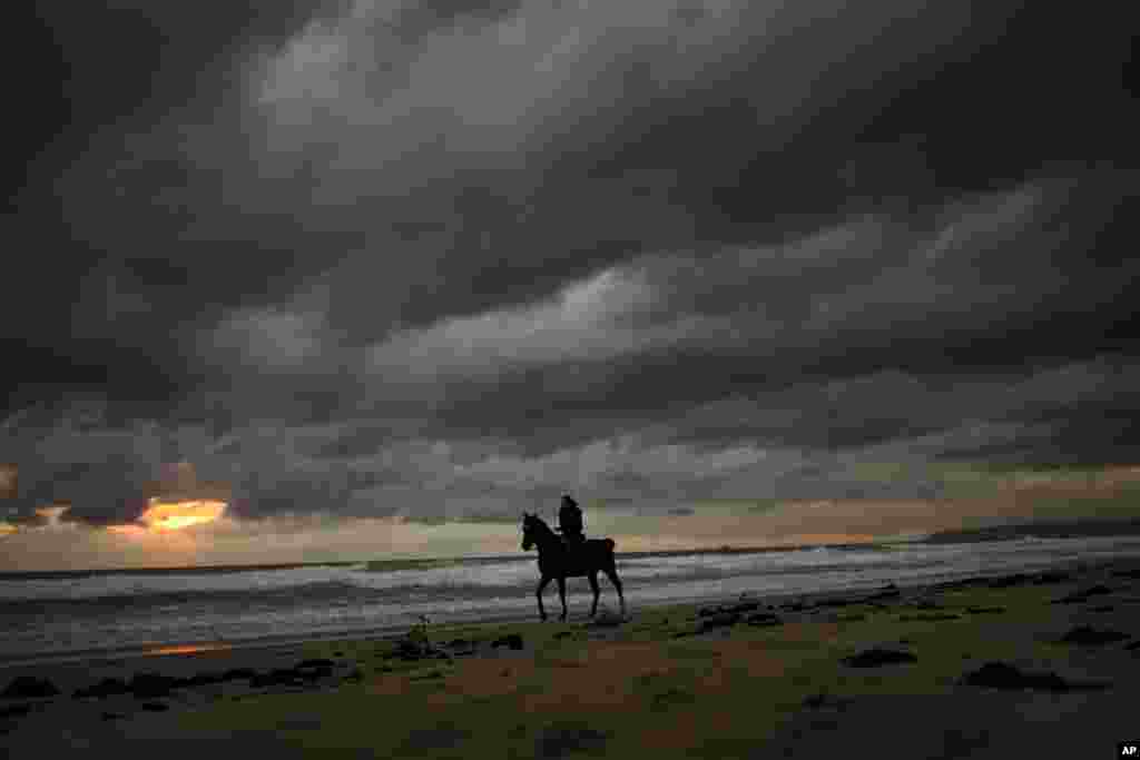 A woman rides a horse along a beach in Cadiz, southern Spain, Oct. 19, 2015.