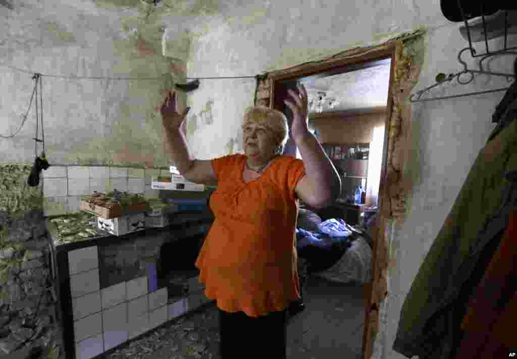 Local resident Valentina Smirnova reacts as she stands in her destroyed house after shelling in Donetsk, eastern Ukraine, Aug. 14, 2014.