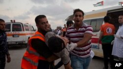 Fələstinli həkimlər Qəzza zolağında İsrailin hava hücumları nəticəsində yaralanmış etirazçını klinikaya çatdıdır, 20 iyul, 2018.
