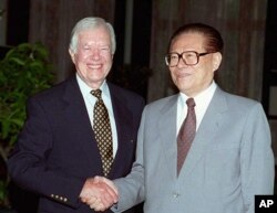 1997年7月24日，美国前总统吉米·卡特与中国国家主席江泽民在北戴河握手。