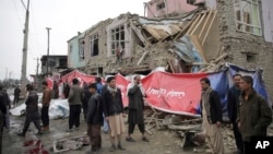 Residents walk though the site of a suicide attack in Kabul, Afghanistan, March 2, 2018. A large explosion in the eastern part of the Afghan capital on Friday morning killed at least one person and wounding others an Afghan official said. 