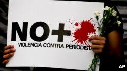 A protestor holds a sign reading "No more violence against journalists," during a demonstration outside the Interior Ministry in Mexico City, Tuesday, May 16, 2017. 