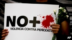 A protestor holds a sign reading "No more violence against journalists," during a demonstration outside the Interior Ministry in Mexico City, Tuesday, May 16, 2017.