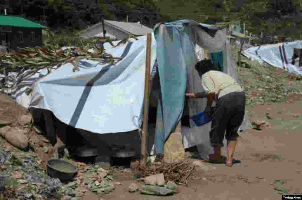 최근 폭우로 인해 피해를 입은 북한 평안남도 성천군 마을의 주민. 13일 교도통신이 보도했다.