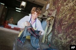 FILE - Forensic scientist Cristina Cattaneo collects post-mortem data from a shipwreck victim at the NATO base in the Sicilian town of Melilli, Italy, Oct. 8, 2016.