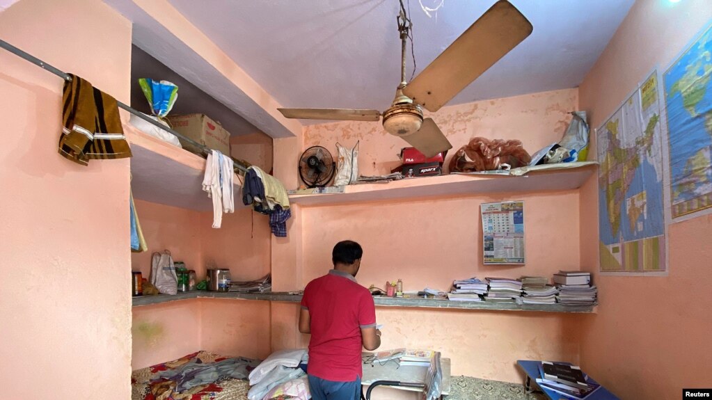 Niranjan Kumar, one of the jobless youth protesting against alleged errors in Indian Railways recruitment, checks out a notebook in his dormitory room in Patna city in the eastern state of Bihar, India, January 29, 2022. 2022. (REUTERS/Krishna N. Das)