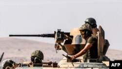 FILE - Turkish soldiers sit on a tank driving to Syria from the Turkish Syrian border city of Karkamis in the southern region of Gaziantep, Aug. 27, 2016. 