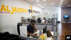 Employees sit in Al-Jazeera news network offices in Jerusalem, Aug. 8, 2017.
