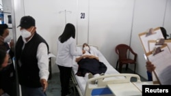 Una trabajadora de la salud descansa en una cama mientras se recupera después de recibir una primera dosis de la vacuna Moderna contra la enfermedad por coronavirus (COVID-19), en el hospital temporal Parque de la Industria en la Ciudad de Guatemala, Guatemala.