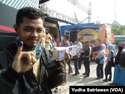 Seorang warga menunjukkan jari bertinta mengantisipasi calo jasa penukaran uang baru di lokasi penukaran uang perbankan di Solo, Solo, 5 Juni 2018. (Foto: VOA/Yudha Satriawan)